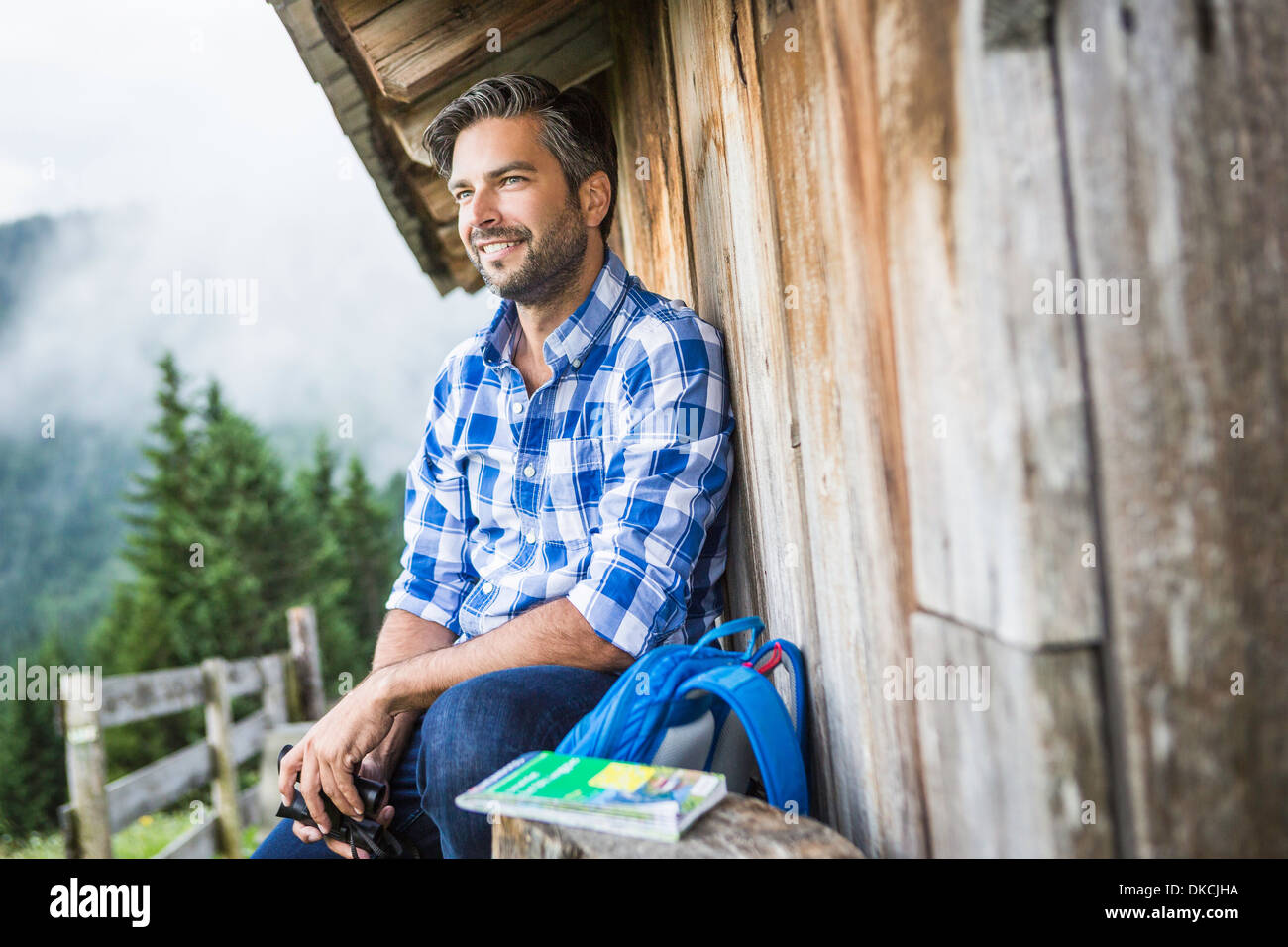 Man enjoying the view from wooden shack, Tirol, Austria Stock Photo