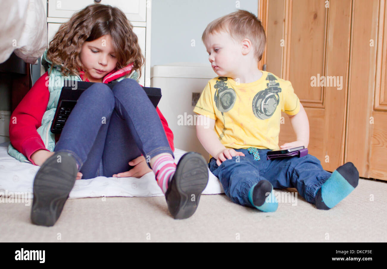 Children using digital tablet and cellular phone Stock Photo