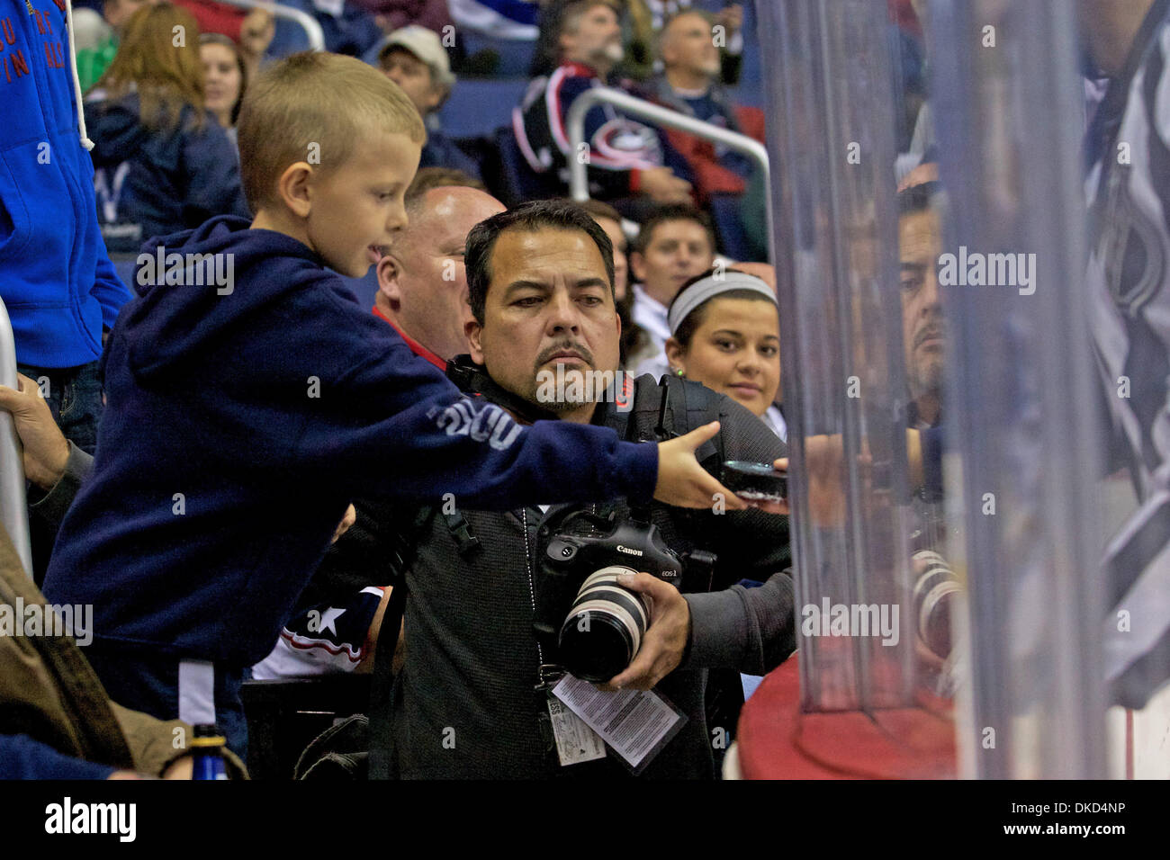 Nov. 3, 2011 - Columbus, Ohio, U.S - A Columbus Blue Jackets fan gets a puck passed to him through the glass by referee during the third period of the game between Toronto Maple Leafs and Columbus Blue Jackets at Nationwide Arena, Columbus, Ohio. Toronto defeated Columbus 4-1. (Credit Image: © Scott Stuart/Southcreek/ZUMAPRESS.com) Stock Photo