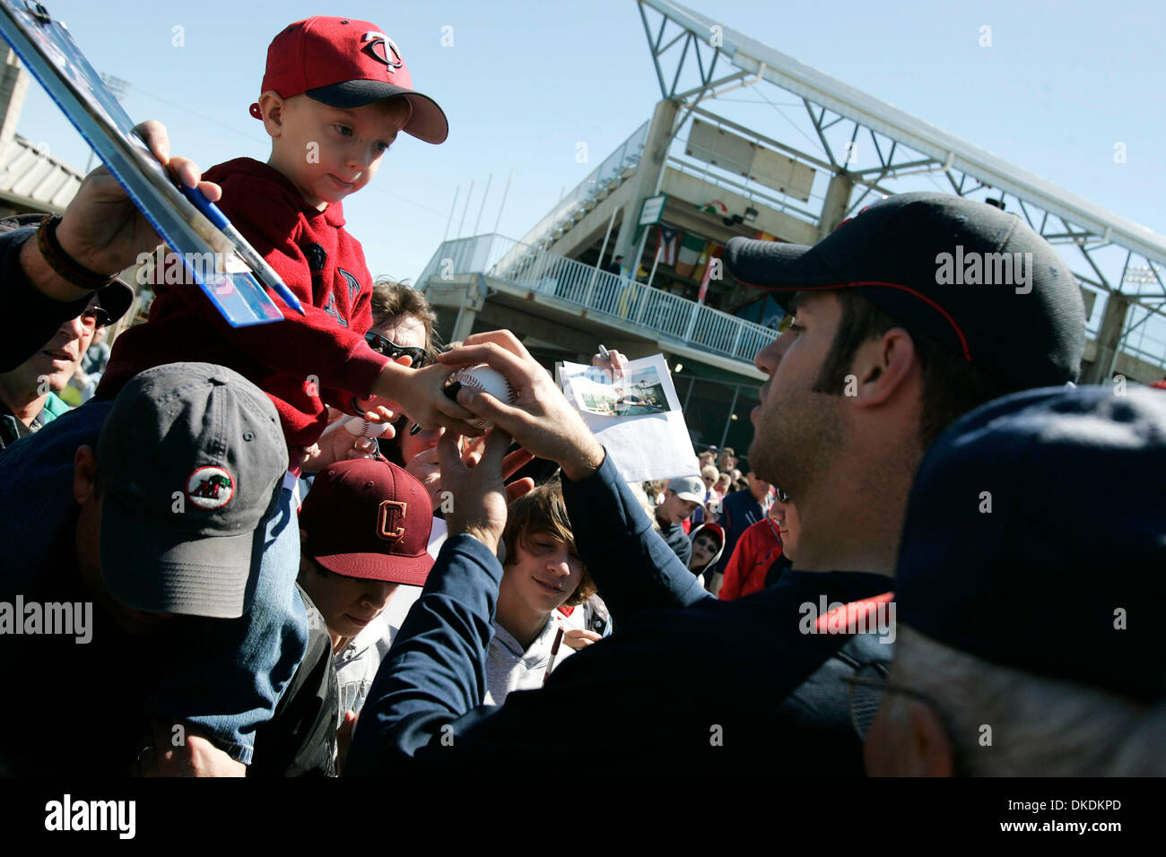 Feb 19, 2007 - Fort Myers, FL, USA - Minnesota Twins catcher JOE MAUER, 2006 American League batting champion, signs a baseball for ANDREW GLEASON, 3, atop the shoulders of his father Matt, at the end of the spring training opener for pitchers and catchers Monday at the Lee County Sports Complex. The Gleasons moved to Fort Myers from St. Paul in 2006 and remain Twins fans.(Credit I Stock Photo