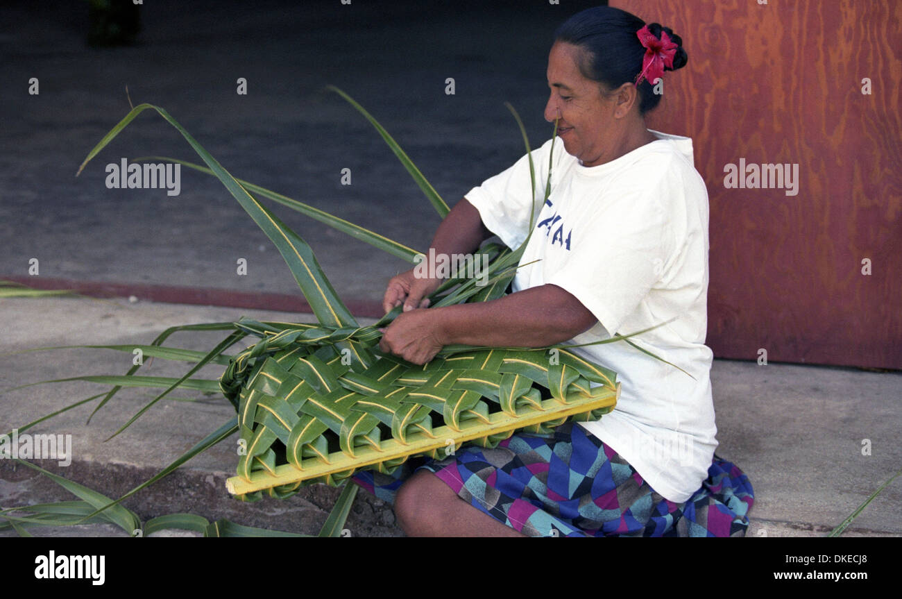 A   Polynesian women weave baskets using materials from the coconut palm. Stock Photo