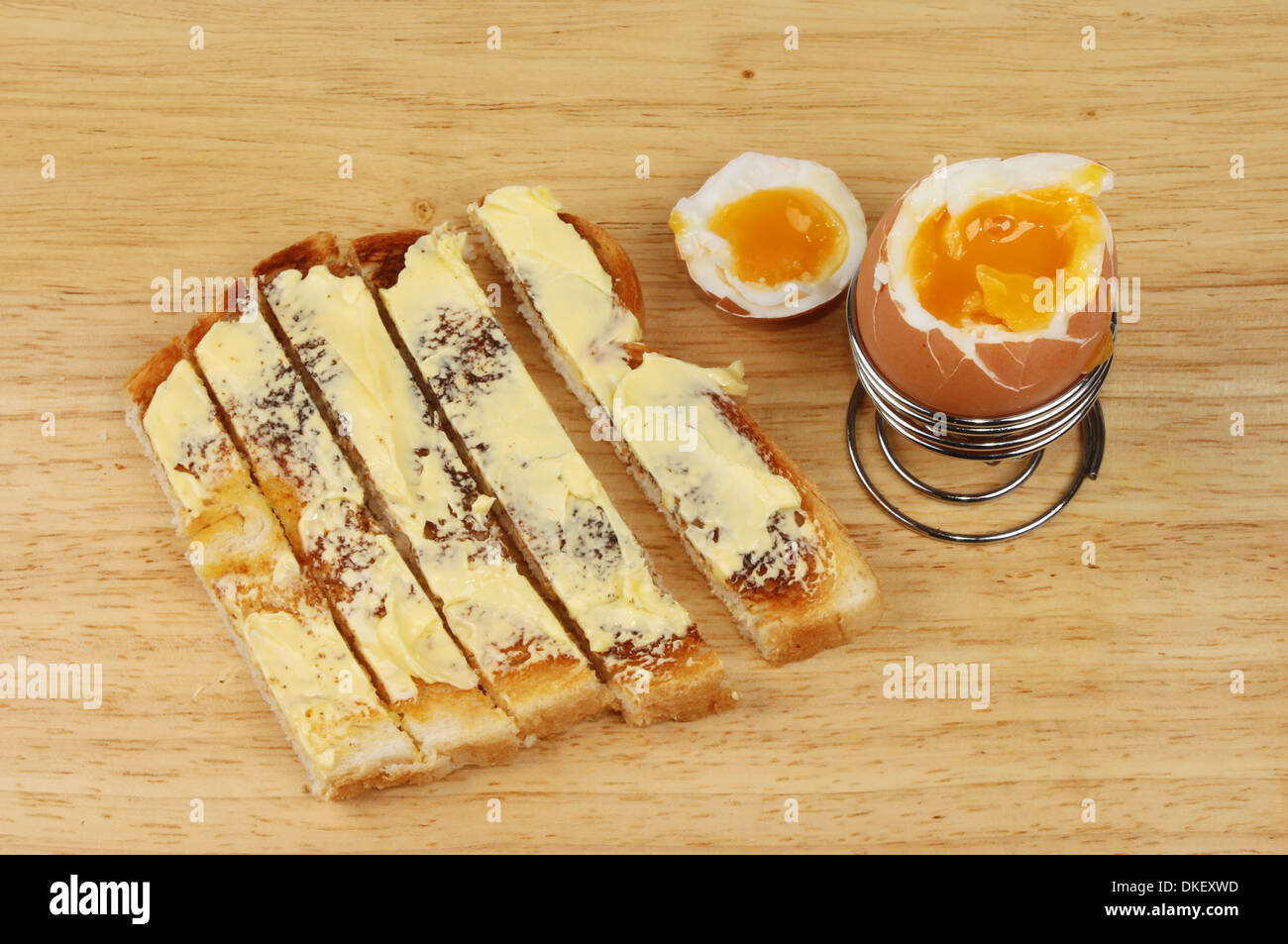 Soft boiled egg and toast soldiers on a wooden board Stock Photo