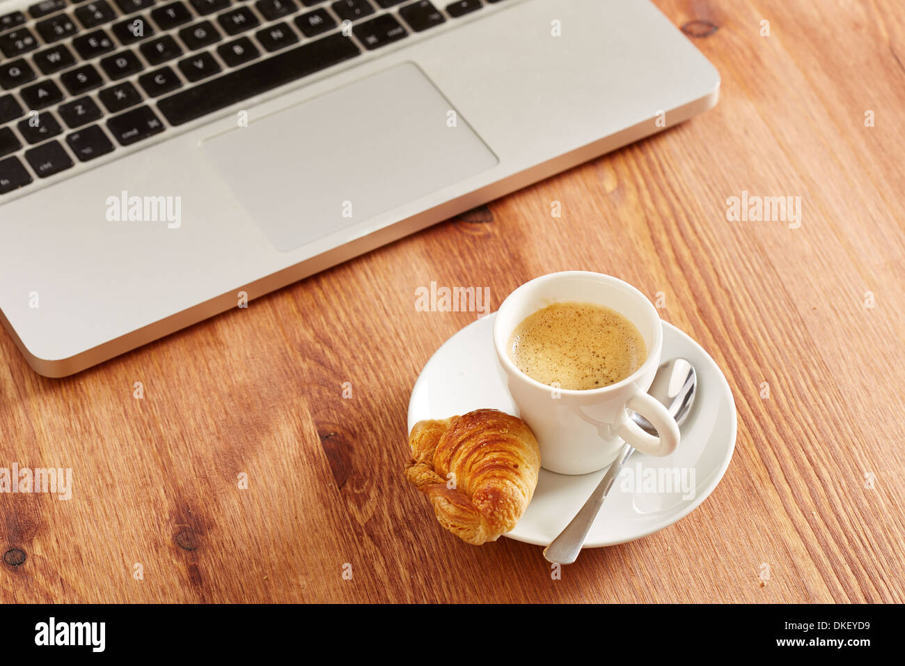 Having breakfast in front of computer on workspace Stock Photo