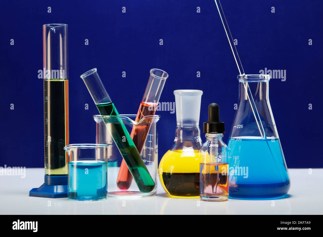 Chemical lab glassware: graduated cylinder, small beaker, beaker with two test tubes, flat-bottom flask, dropper bottle Stock Photo