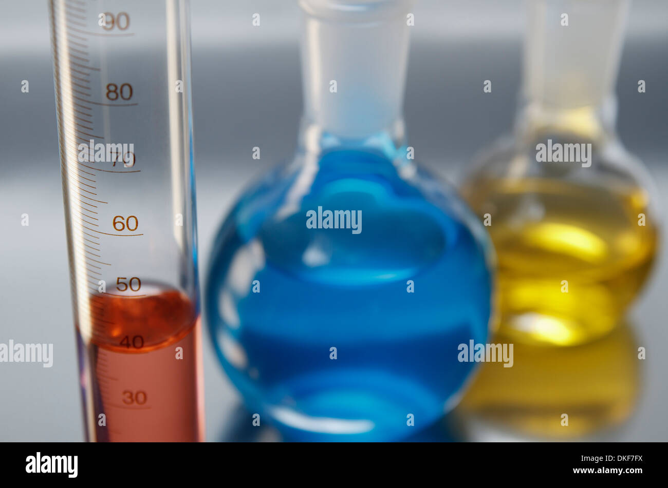 Chemical lab glassware, graduated cylinder and two flat-bottom flasks Stock Photo