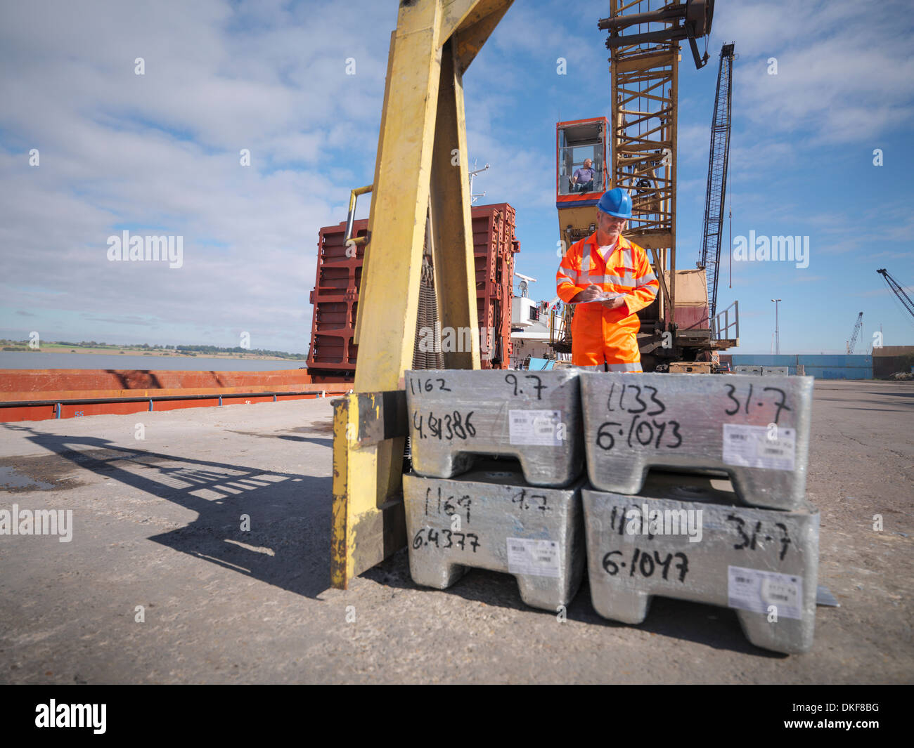 Worker inspecting metal alloy unloaded from ship Stock Photo
