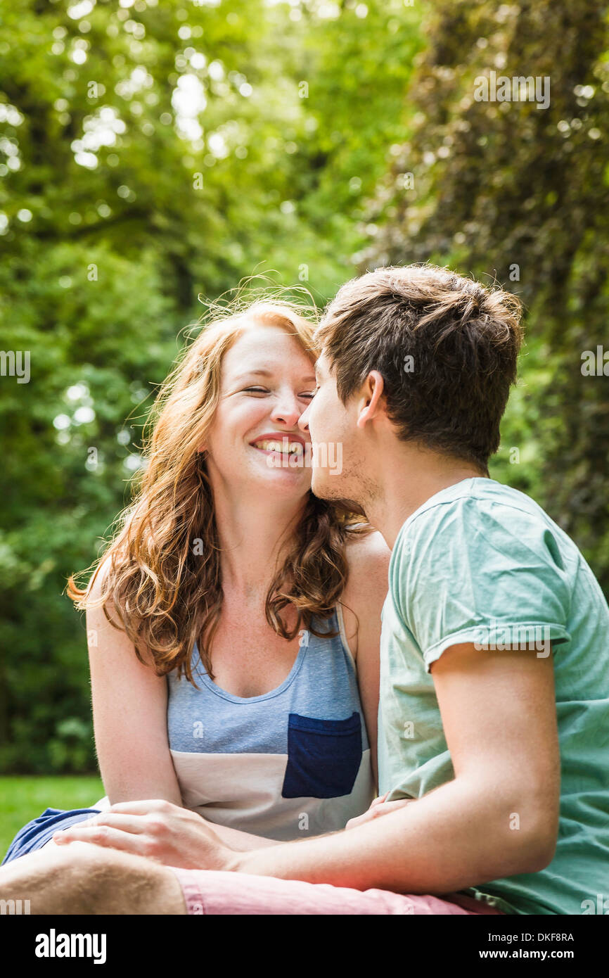 Young couple sitting in park Stock Photo