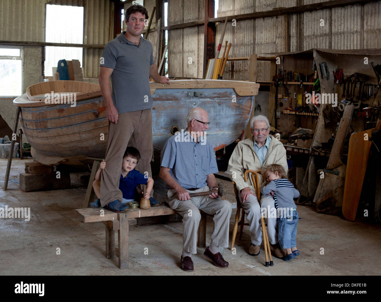 Group portrait of four generations of male boat builders Stock Photo