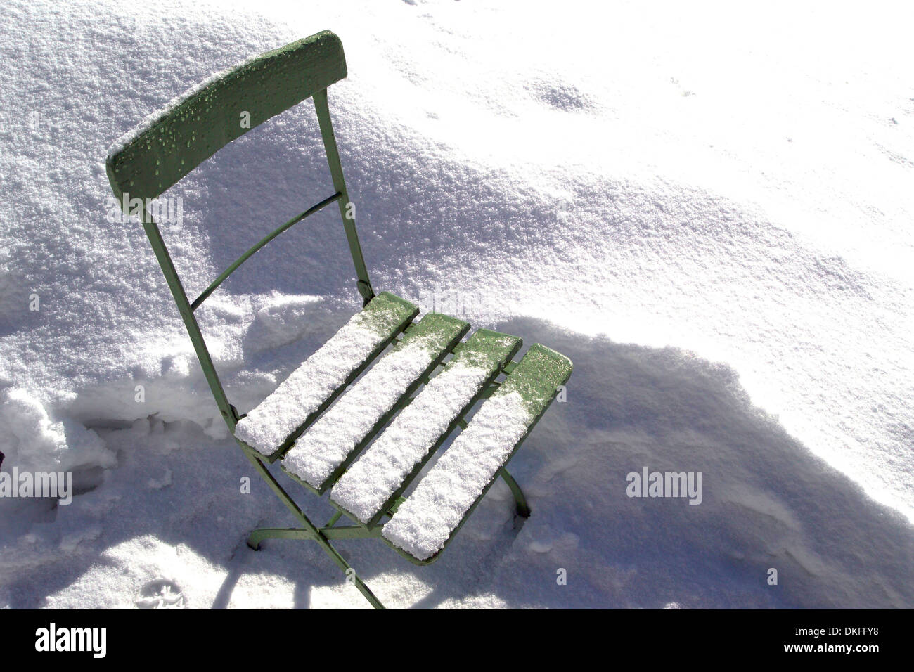 Snow-covered green garden chair Stock Photo