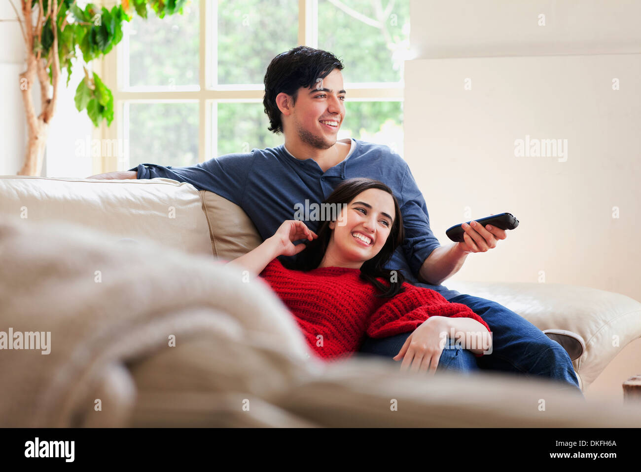 Young couple watching TV on living room sofa Stock Photo Alamy