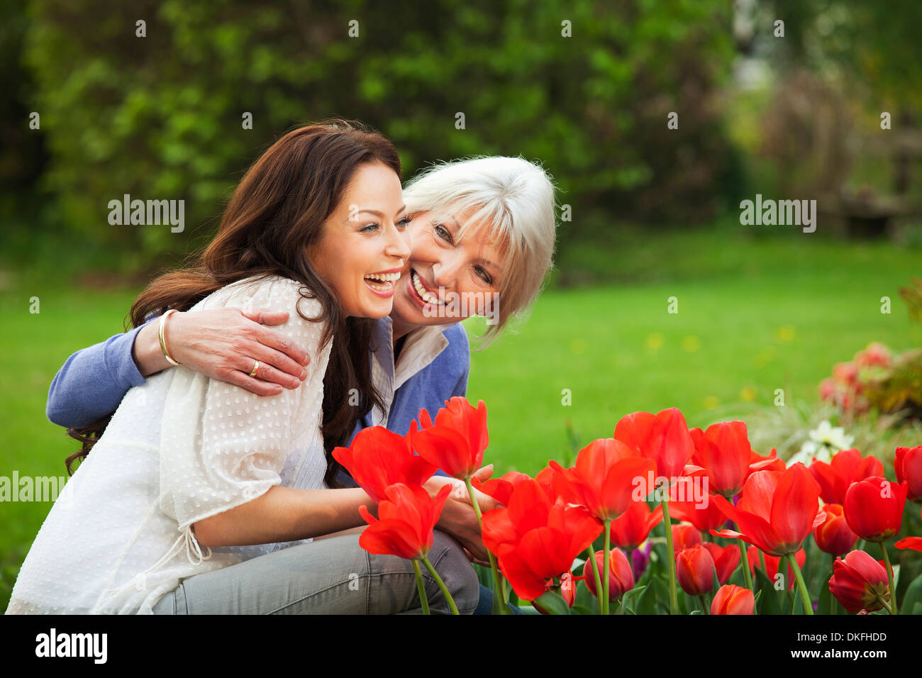 Mother and daughter by red tulips Stock Photo
