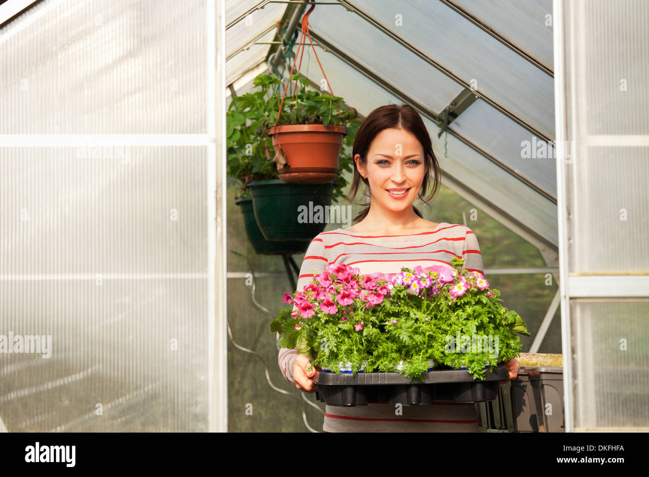 Young woman holding plants Stock Photo