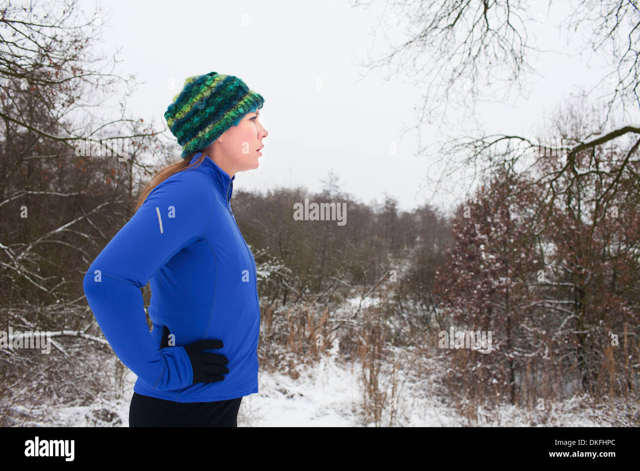 Female runner taking a break in winter scene Stock Photo