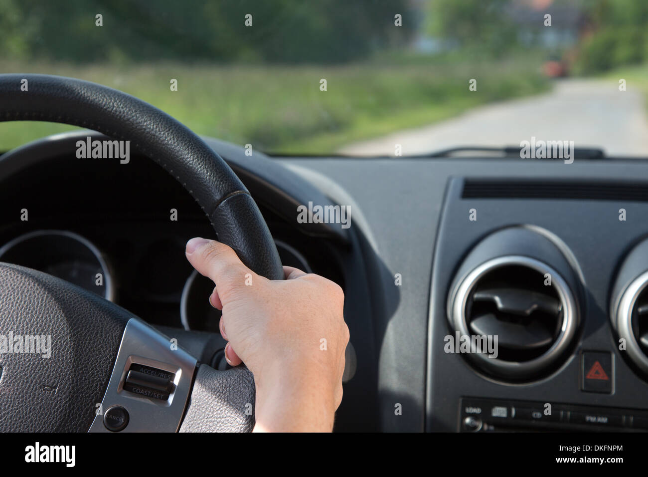 A young woman is holding the steering wheel while driving the car Stock Photo