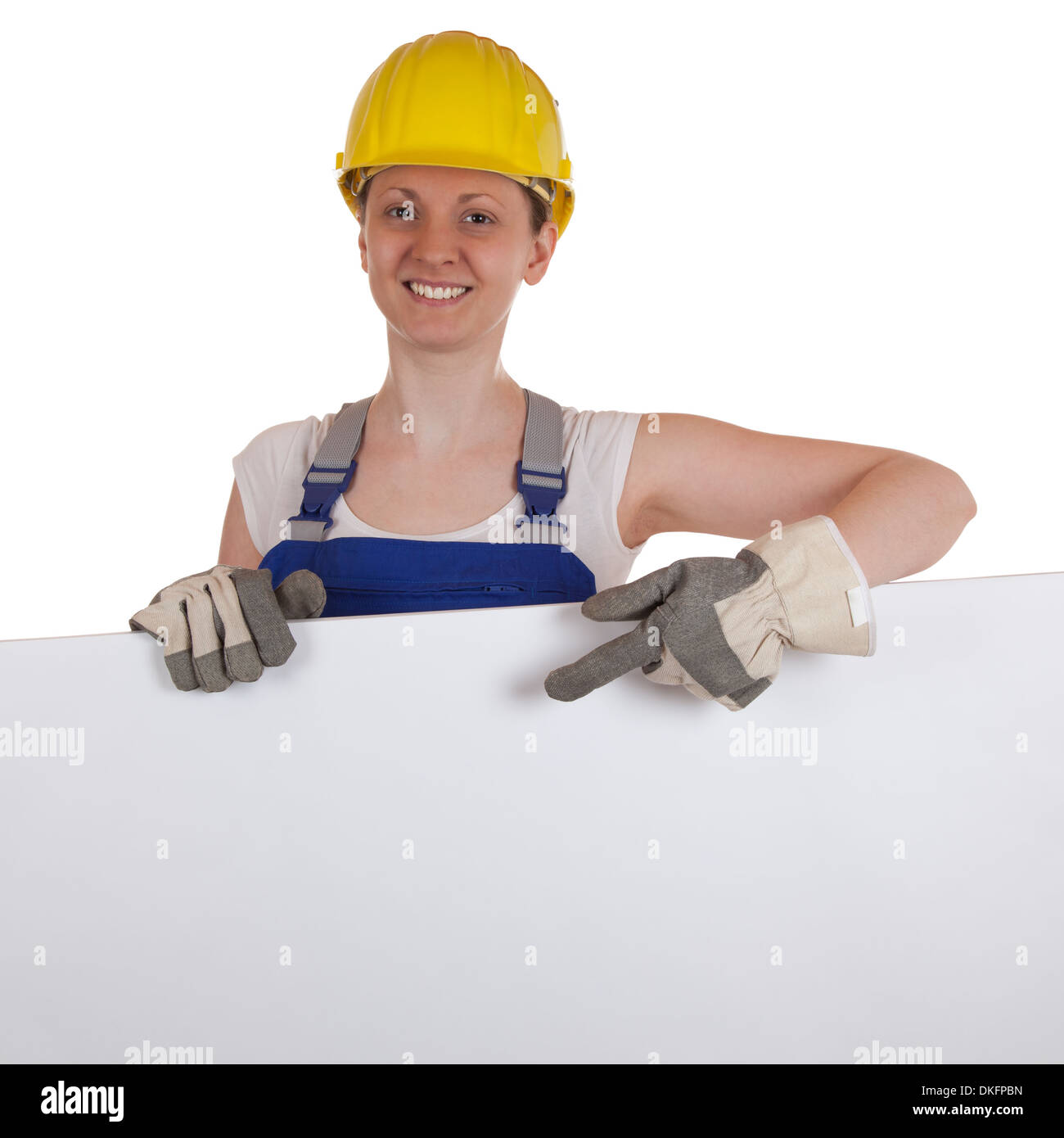 Young female carpenter showing on a white sign with copy space Stock Photo
