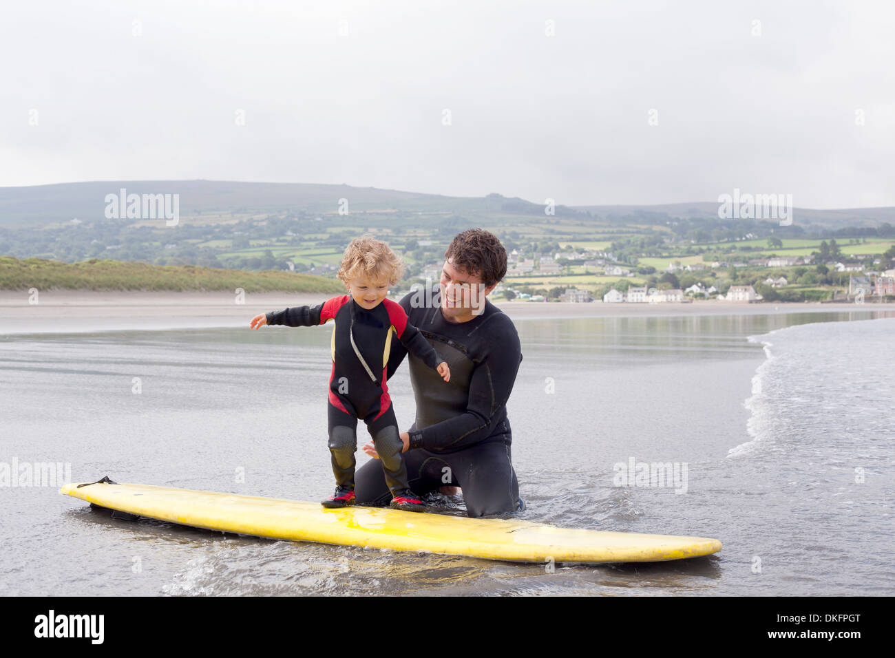 Father teaching son how to surf Stock Photo