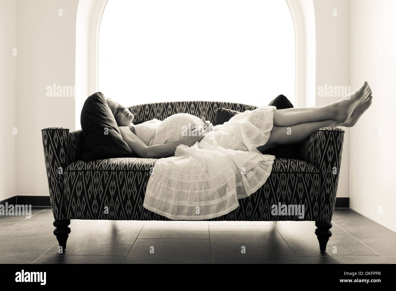 Pregnant woman lying on sofa Stock Photo