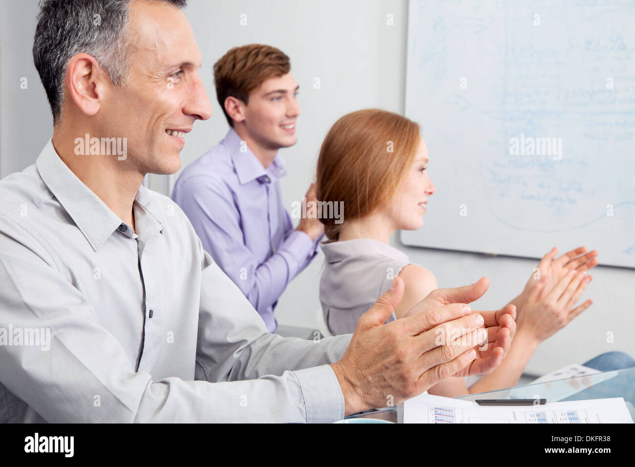 Business colleagues clapping in meeting Stock Photo