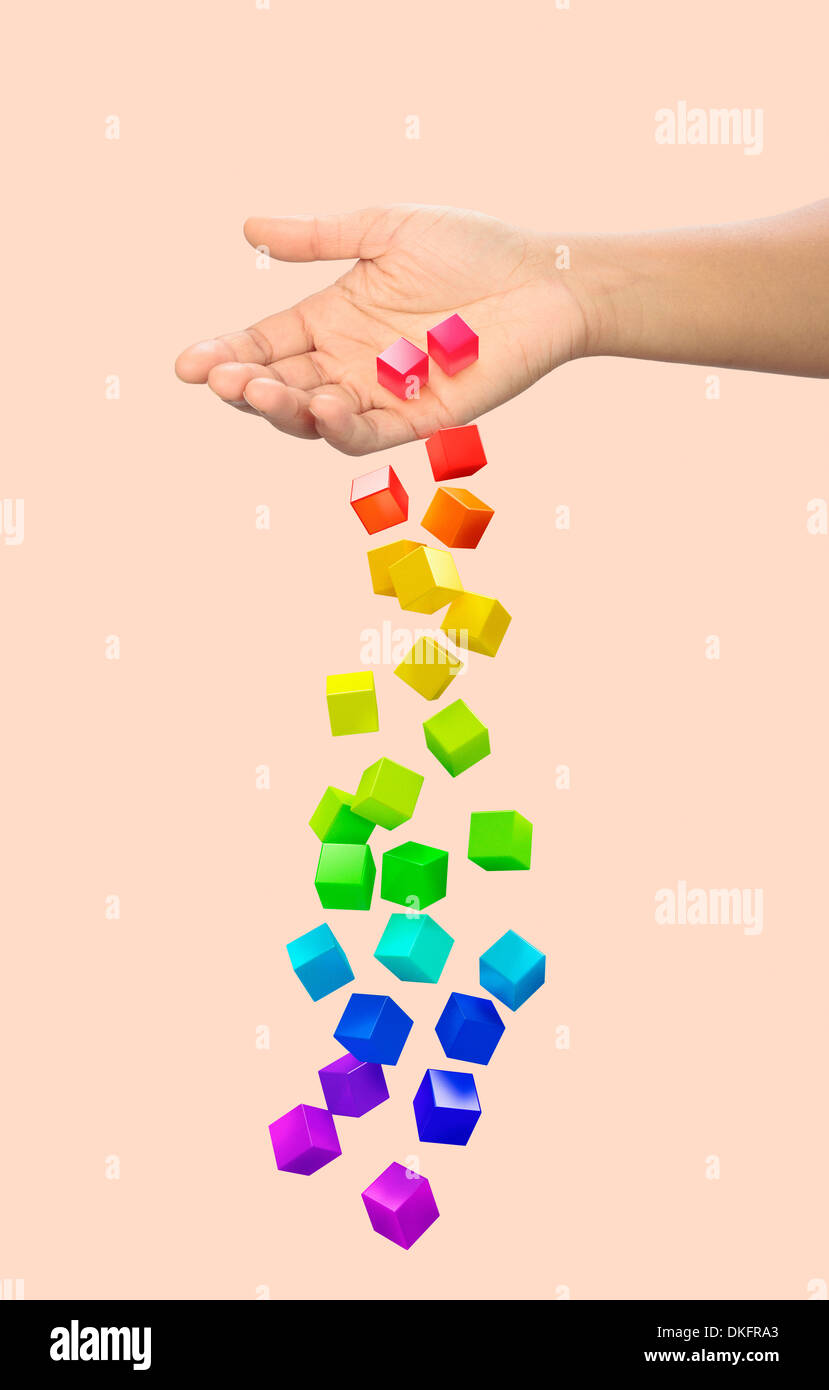 Hand dropping multi coloured blocks Stock Photo