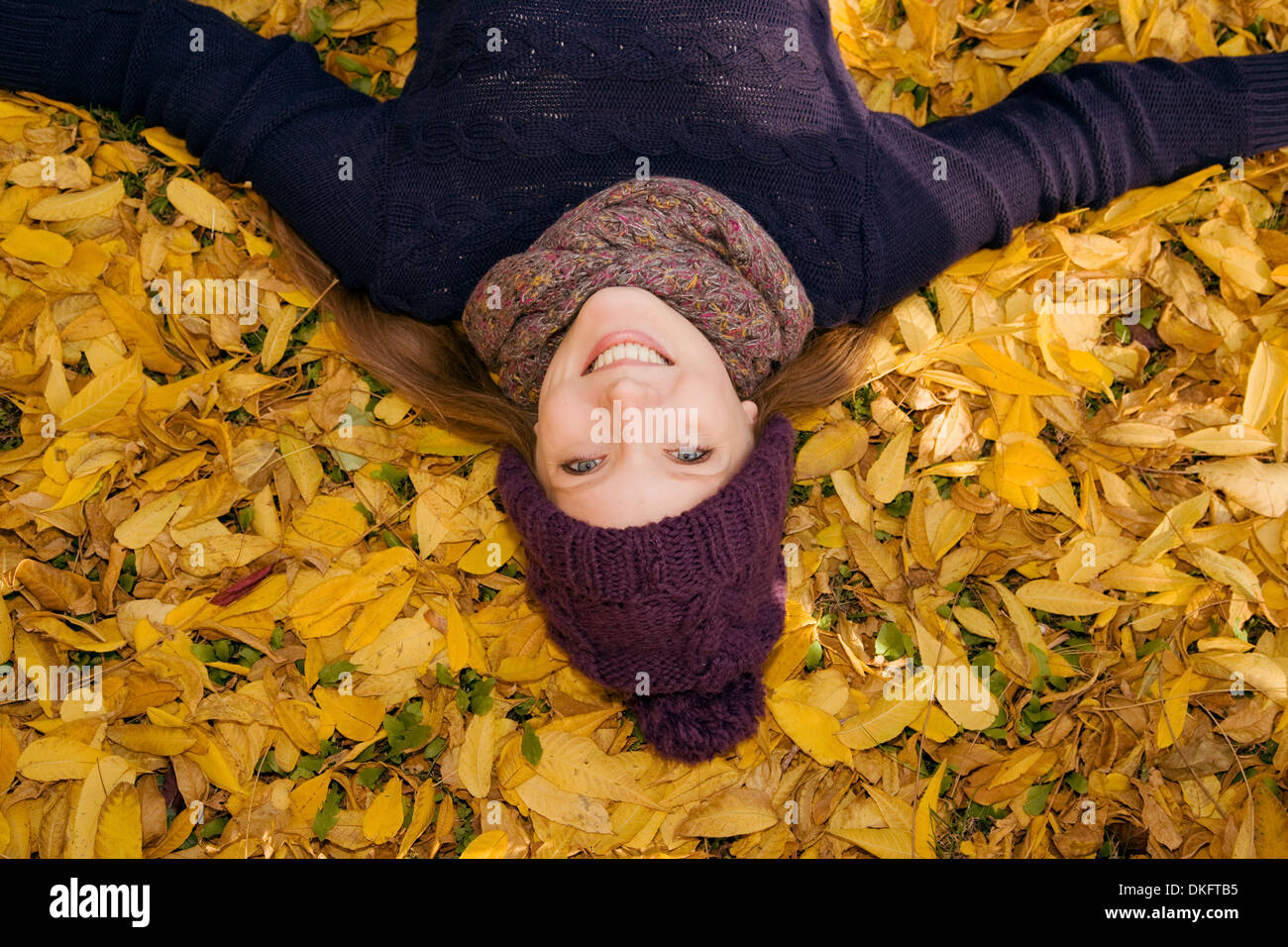 Young woman lying in autumn leaves Stock Photo - Alamy