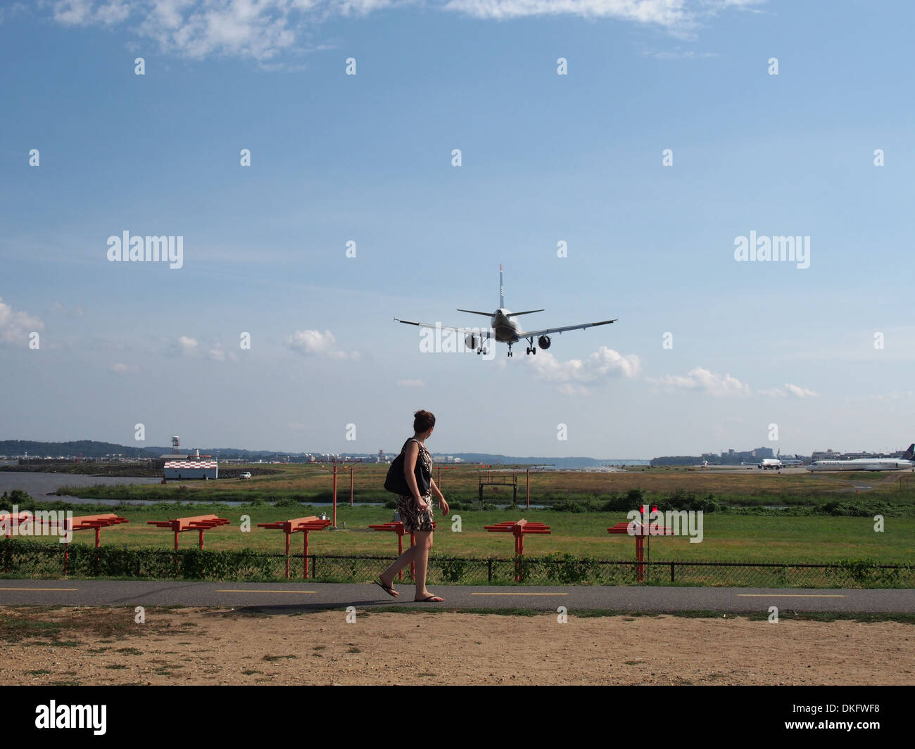 Woman watching plane landing at Reagan National Airport from Gravelly