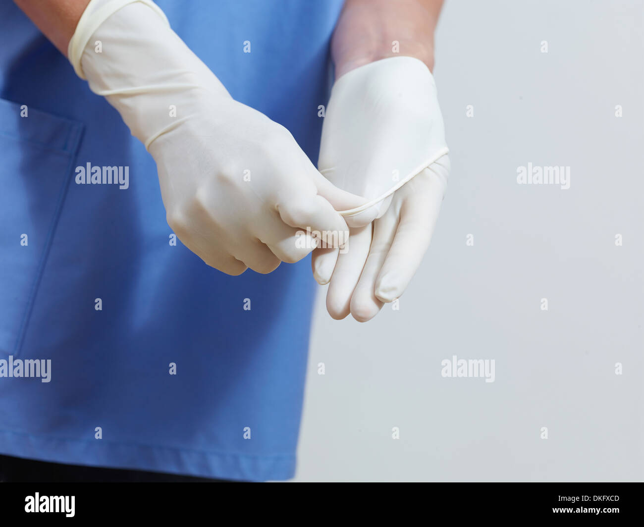 Surgeon putting on latex gloves Stock Photo