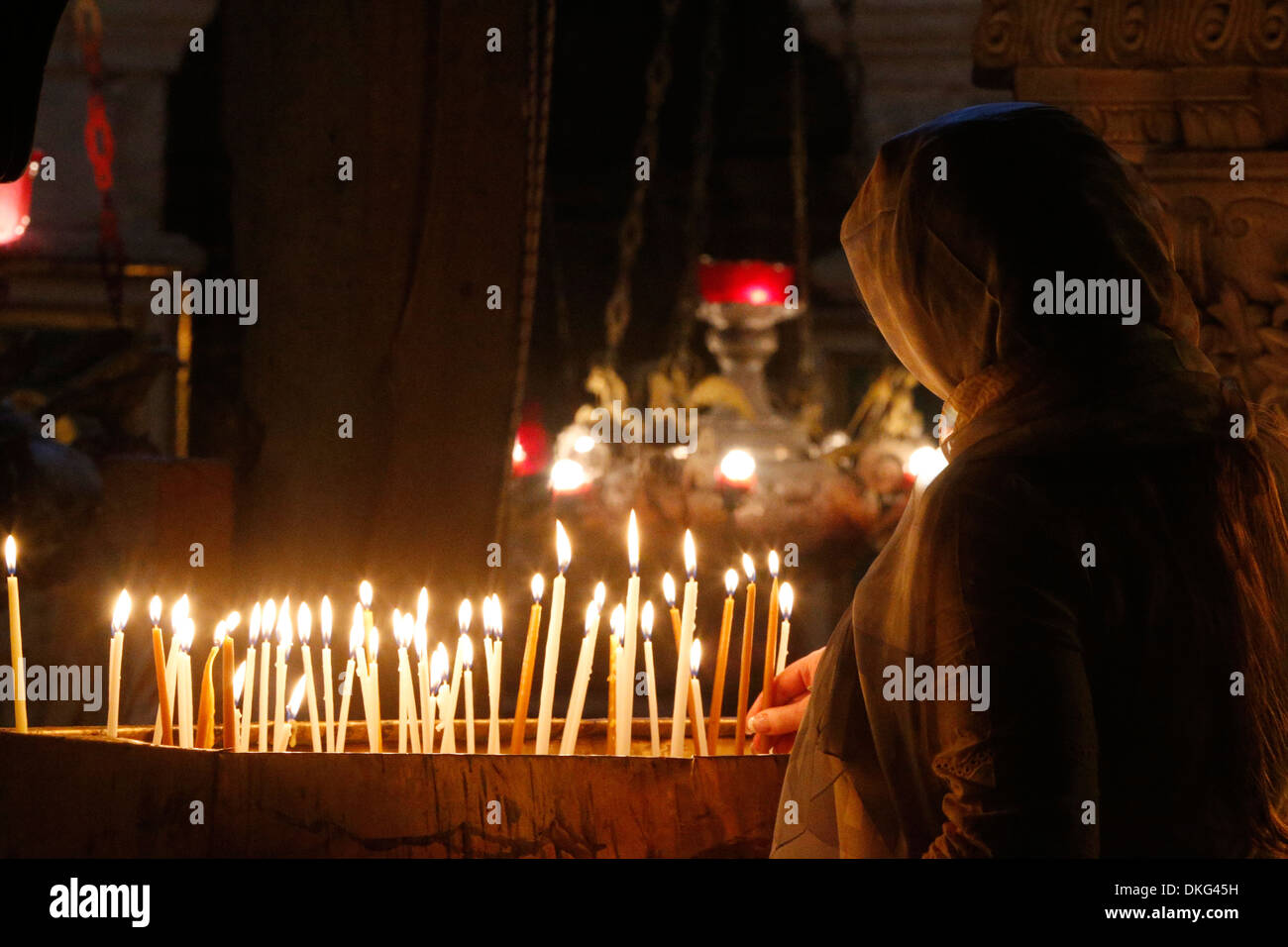 Pilgrim lighting candles in the Holy Sepulchre Church, Jerusalem