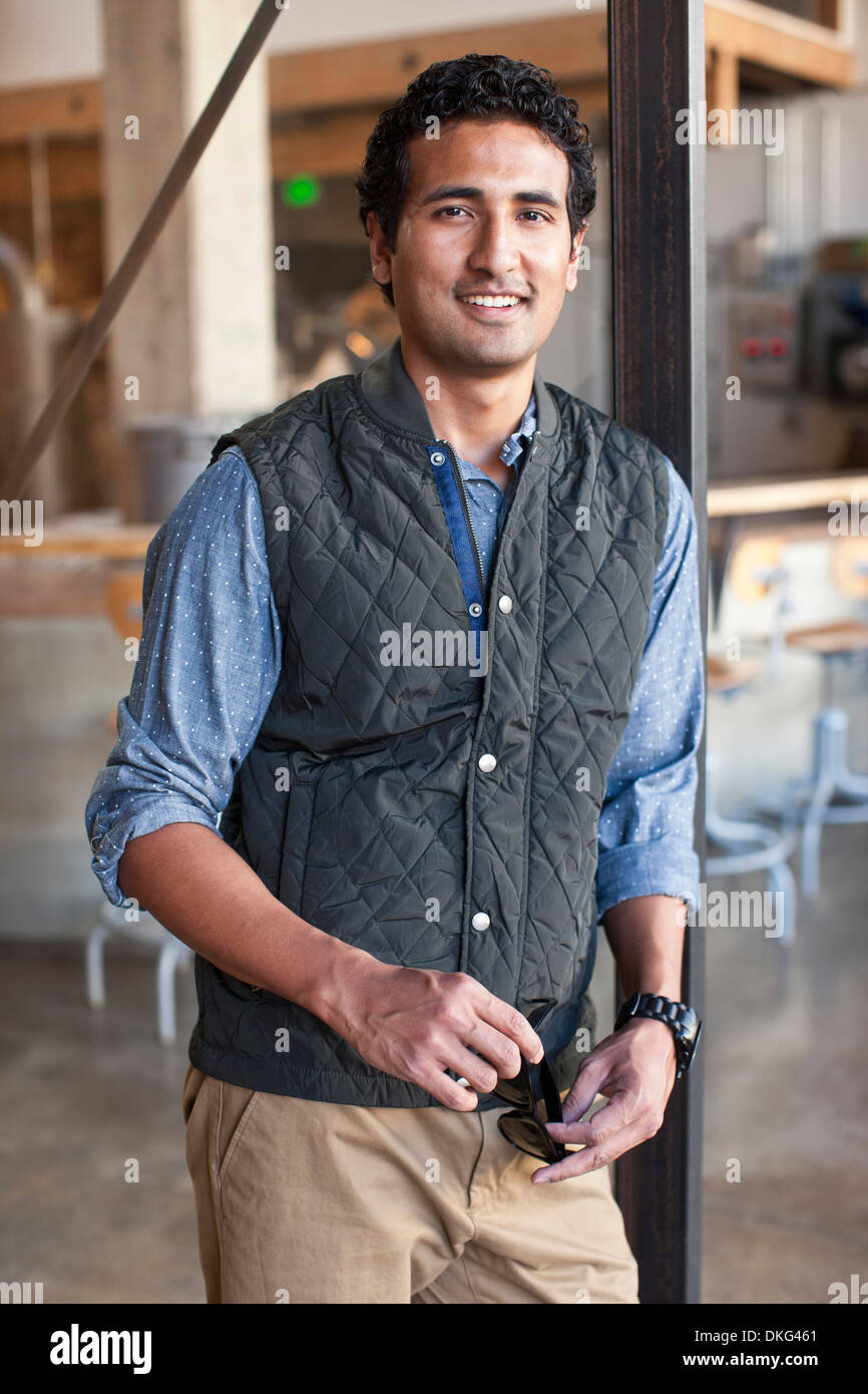 Portrait of young man leaning against wooden post Stock Photo