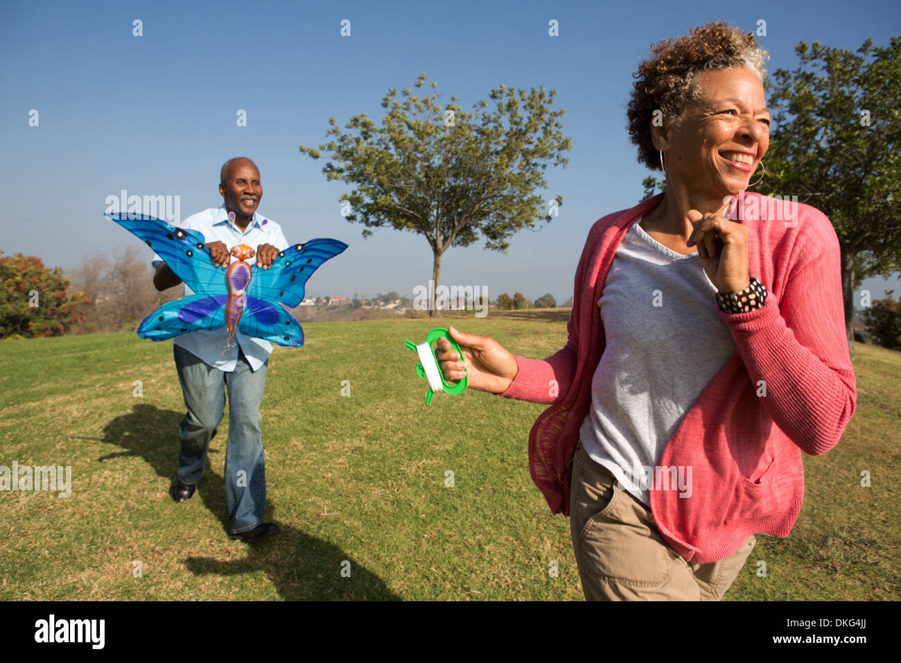 Senior couple running in park with kite Stock Photo