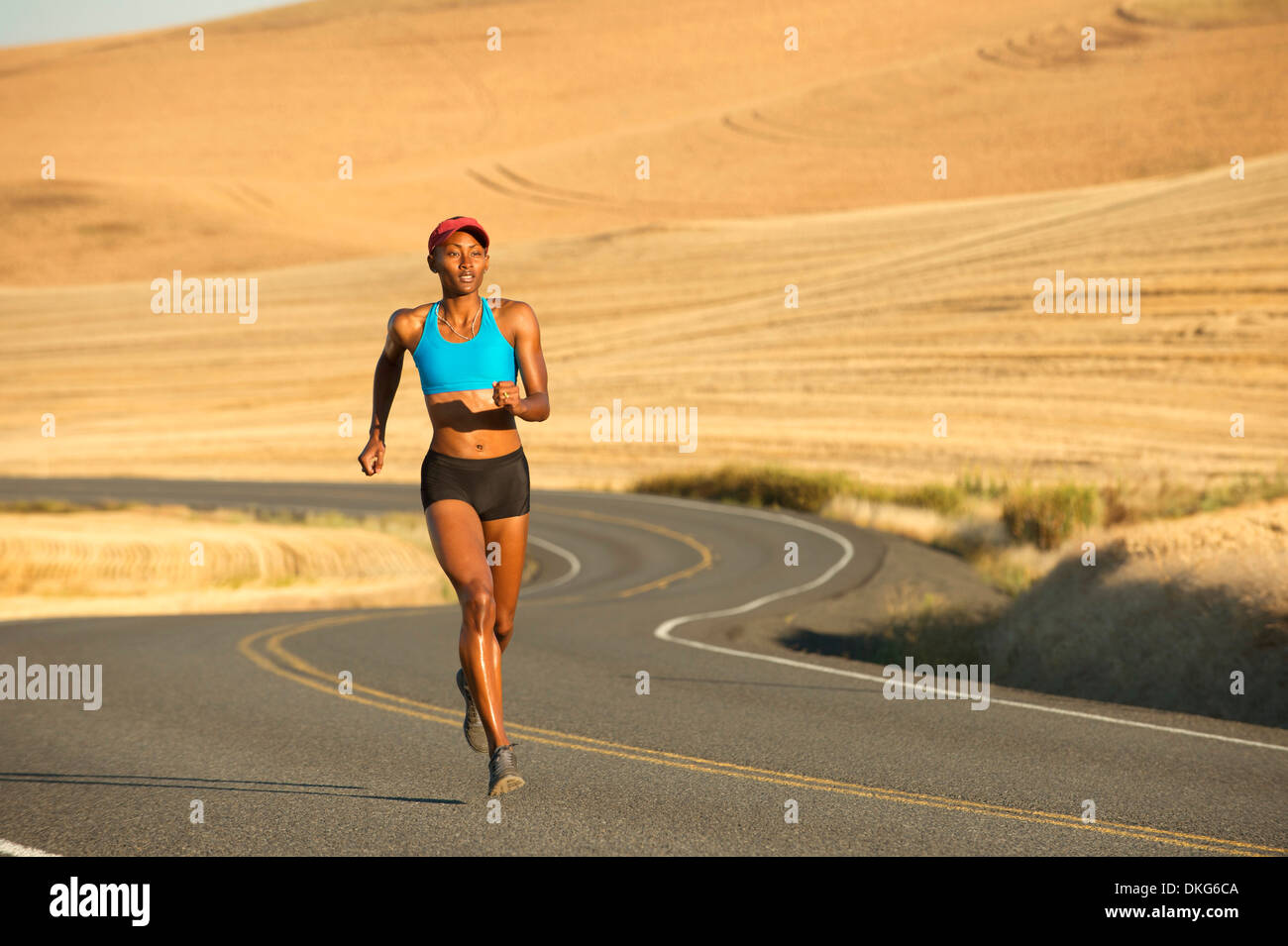 Young woman running on road, Bainbridge Island, Washington State, USA Stock Photo