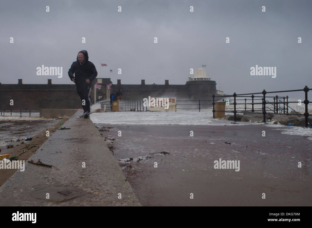 Man walking in storm at Fort Perch Rock in New Brighton, Wirral, Merseyside, United Kingdom Stock Photo