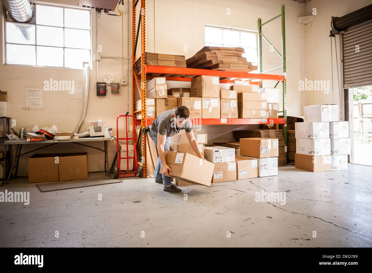 Worker lifting cardboard box Stock Photo