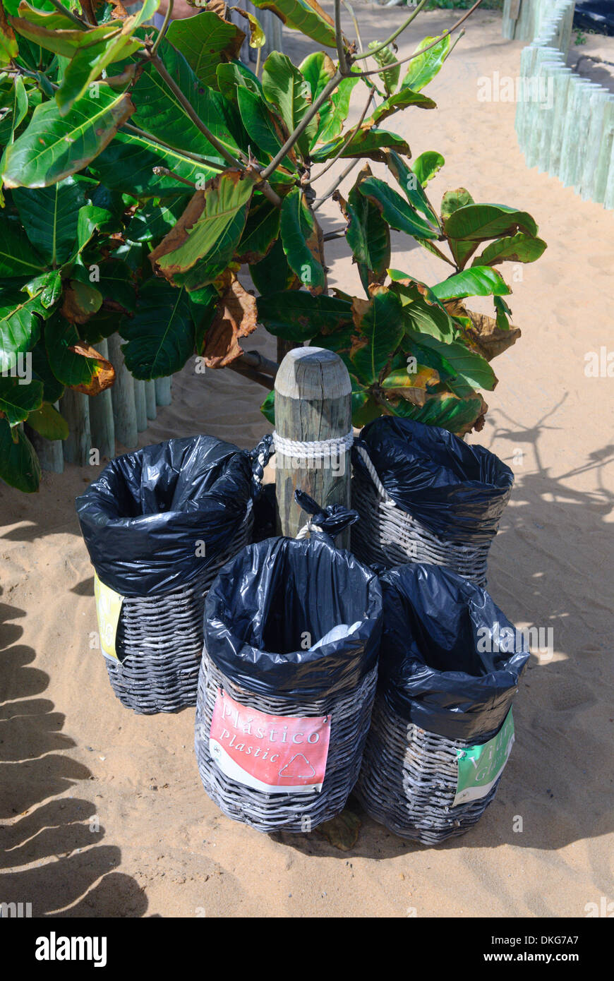 Brazil. Bahia, Praia do Forte. Four coloured waste bins for glass, paper, metal and plastics. Stock Photo