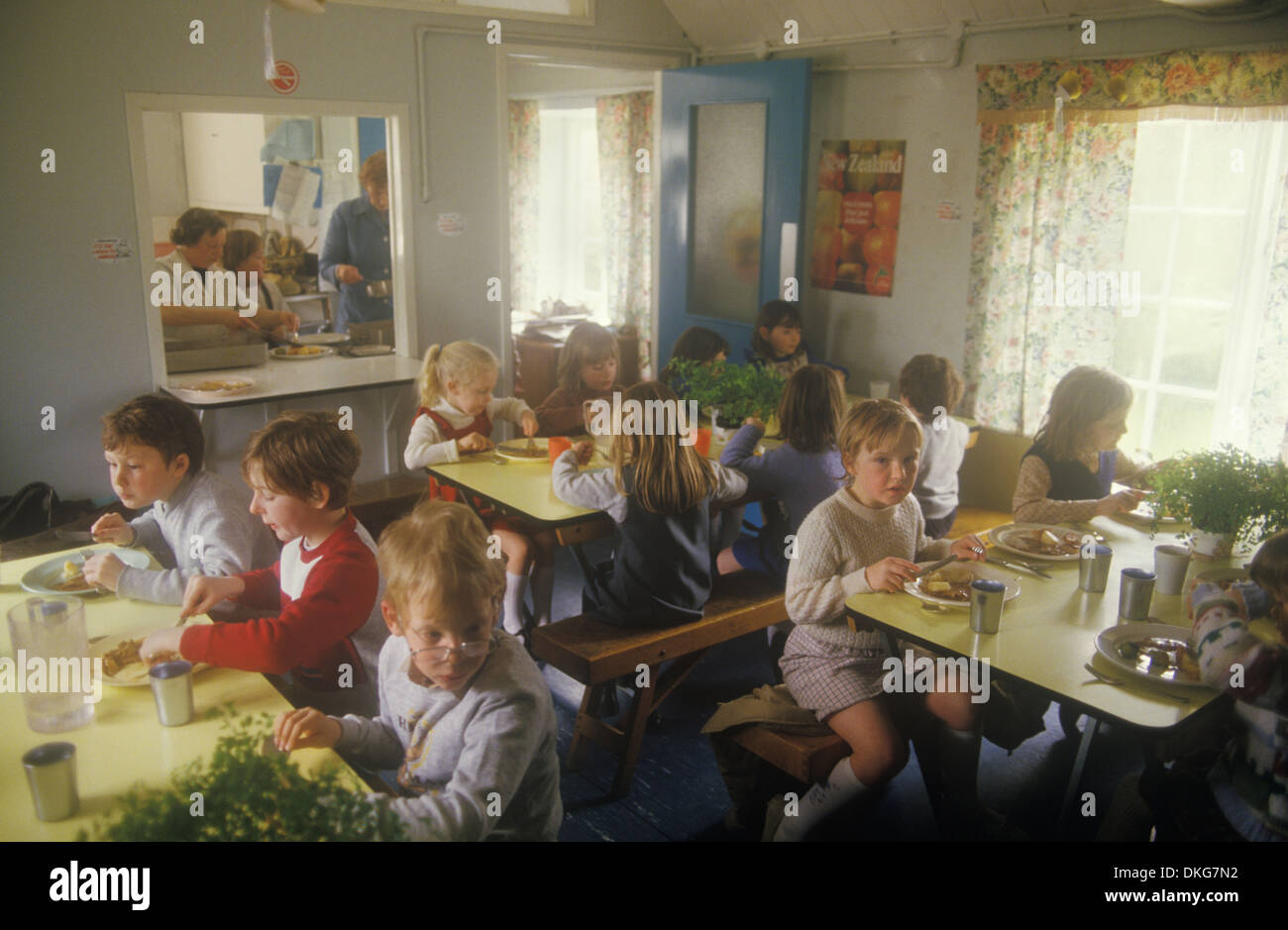 Village junior school lunch time break. Lunch Hour dinner is being prepared through the hatch. Sapperton Gloucestershire 1980s UK HOMER SYKES Stock Photo