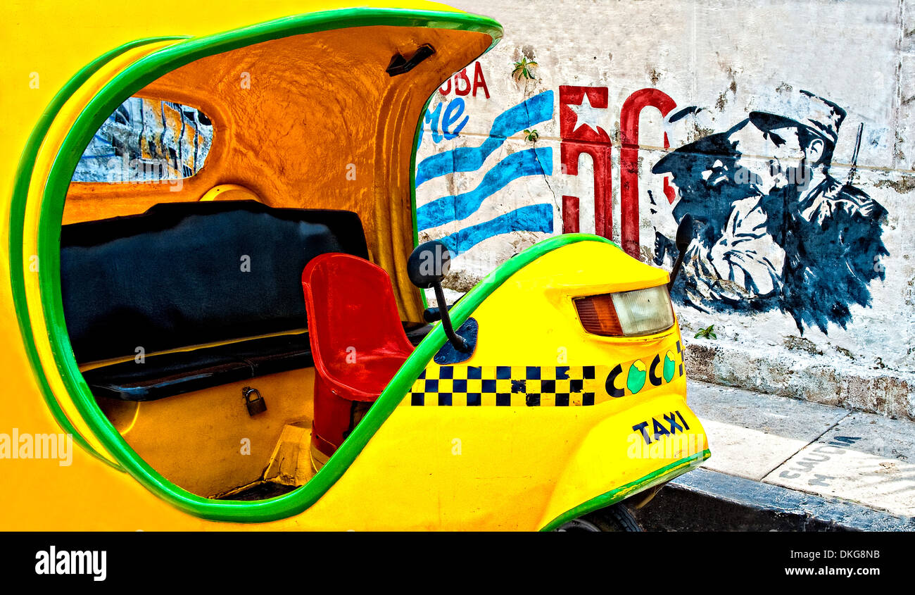 Cuban CoCo Taxi in front of Castro and Guevara graffiti Stock Photo