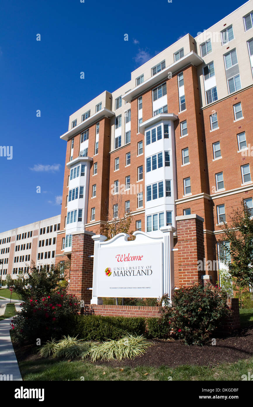 An entrance sign to the University of Maryland in College Park, MD with resident halls and parking garage in the background. Stock Photo