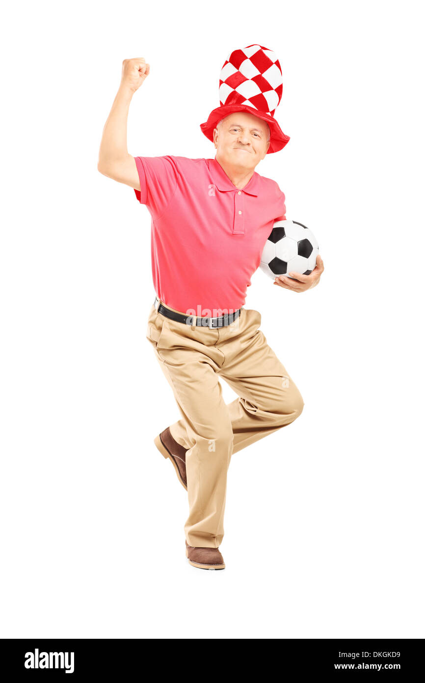 Full length portrait of a middle aged sport fan with hat holding a soccer ball and gesturing happiness Stock Photo