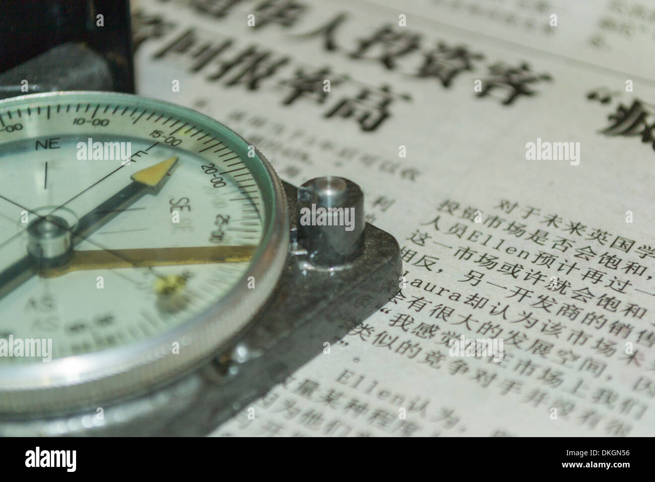 Compass pointing East on a Chinese newspaper Stock Photo