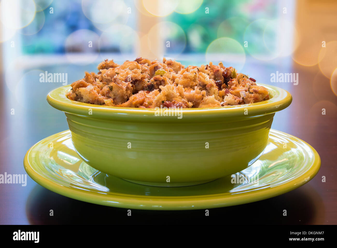 Thanksgiving Day Turkey Stuffing with Corn Bread Celery Cranberry in Green Bowl on Wood Table with Blurred Bokeh Lights Stock Photo