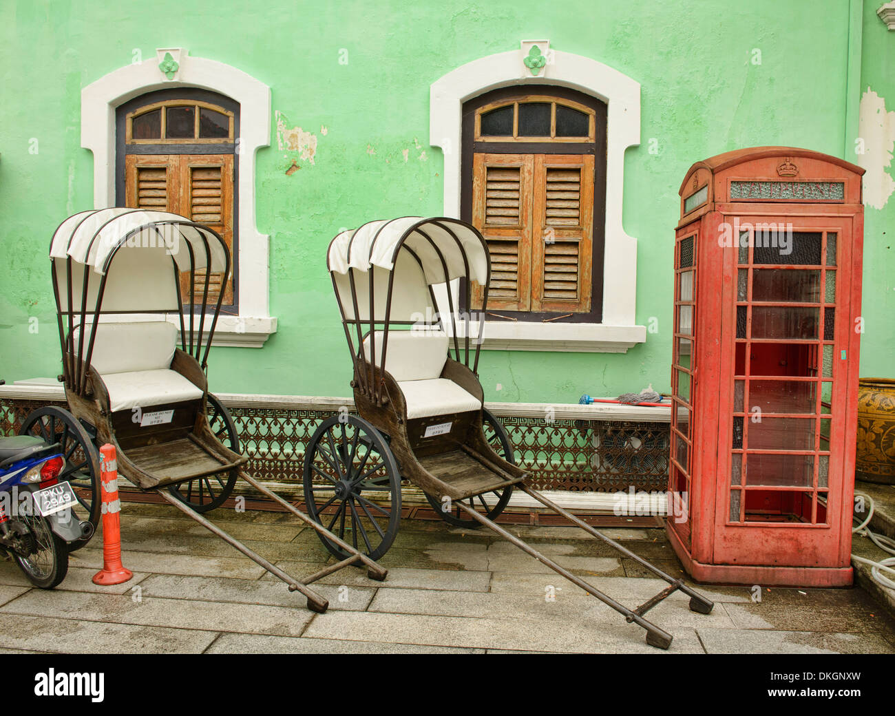 trishaws and phone booth at the Pinang Peranakan Mansion in Georgetown, Penang, Malaysia Stock Photo