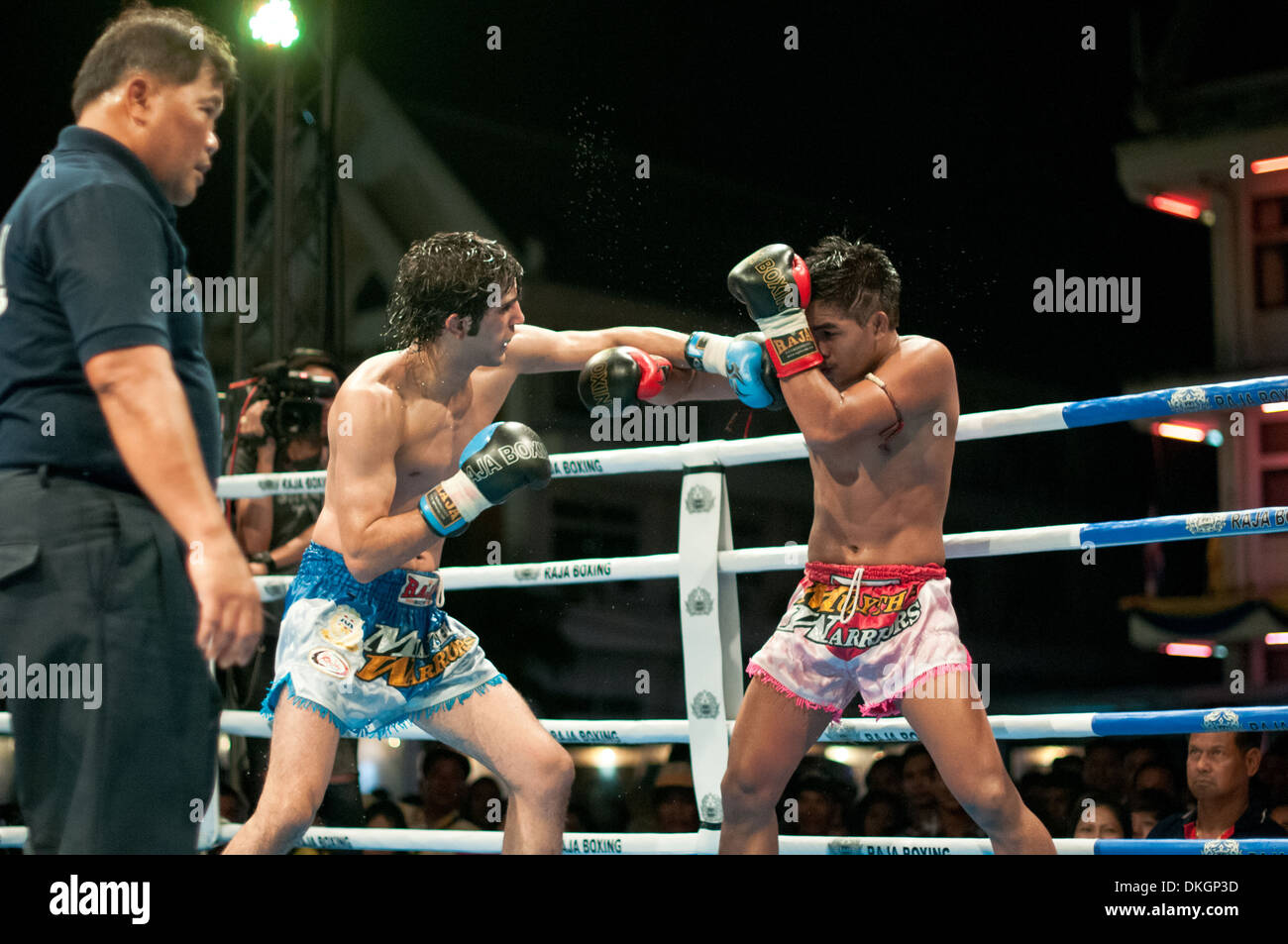 Iranian Thai Boxer punches his opponent in the King's Birthday Max Muay Thai Warrior Fight 2013 Stock Photo