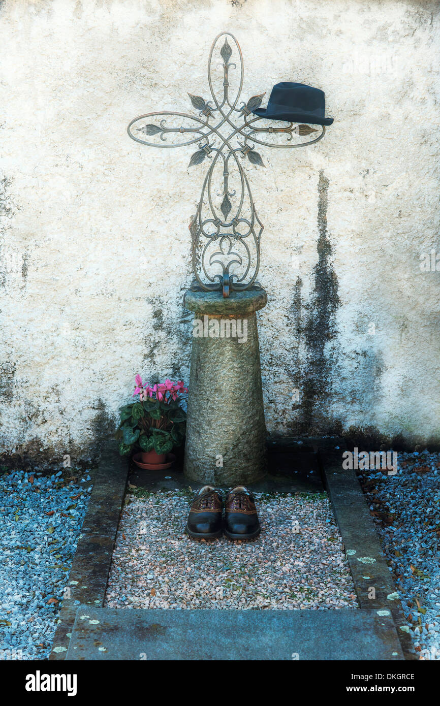 a black hat and a pair of men's shoes on a grave Stock Photo