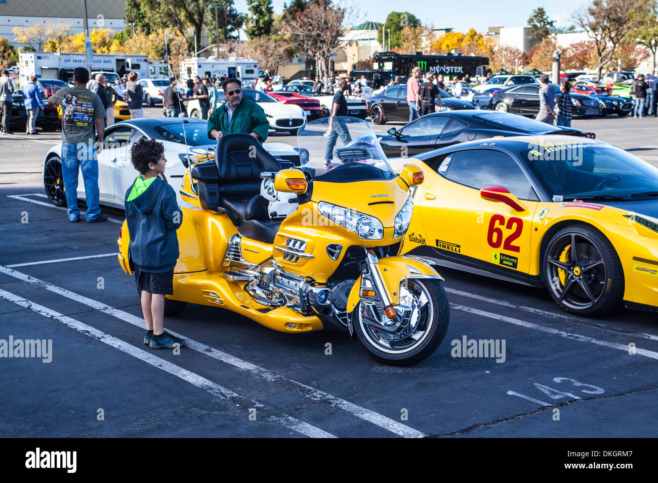 A custom three wheel Motorcycle next to a Ferrari race car Stock Photo