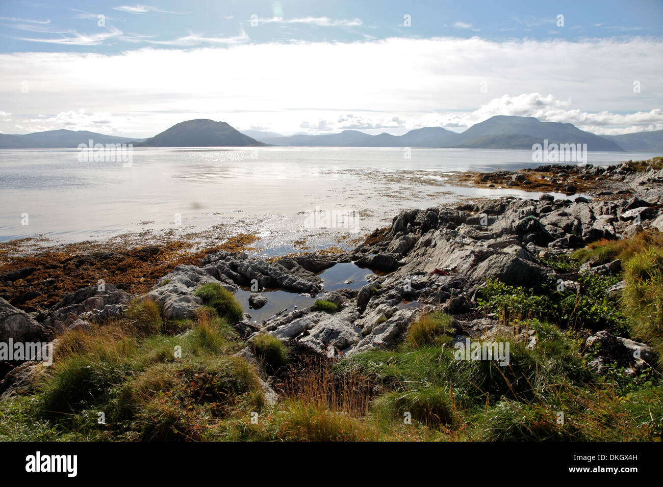 Sunlit rocks and foreshore, Helgoy, Kvalsund, Troms, North Norway, Norway, Scandinavia, Europe Stock Photo