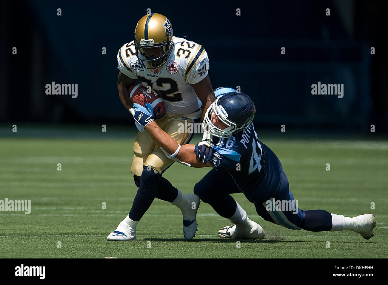 Winnipeg Blue Bomber RB Fred Reid #32 gets tackled by Toronto