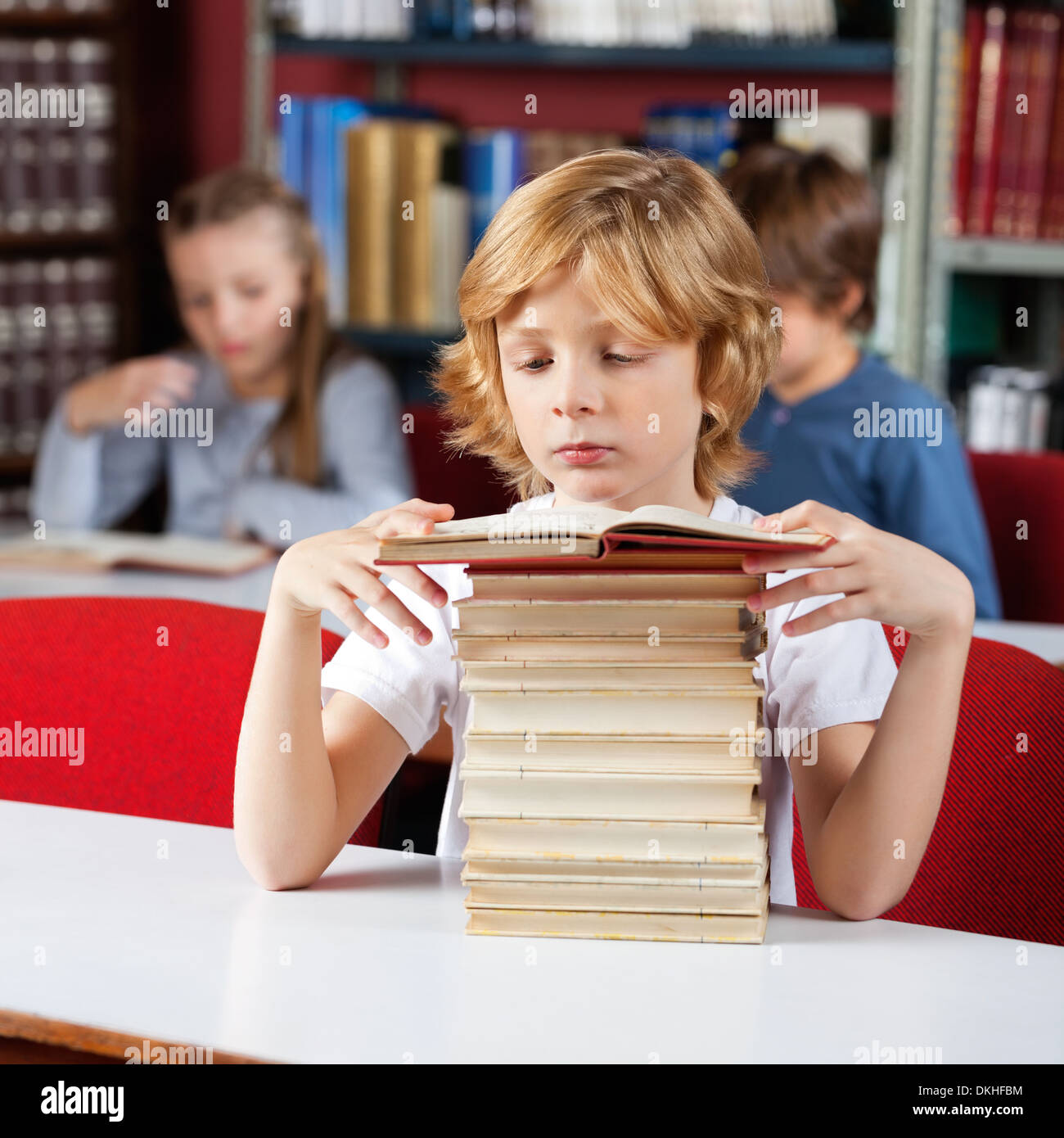 Schoolboy With Stack Of Books Stock Photo - Alamy