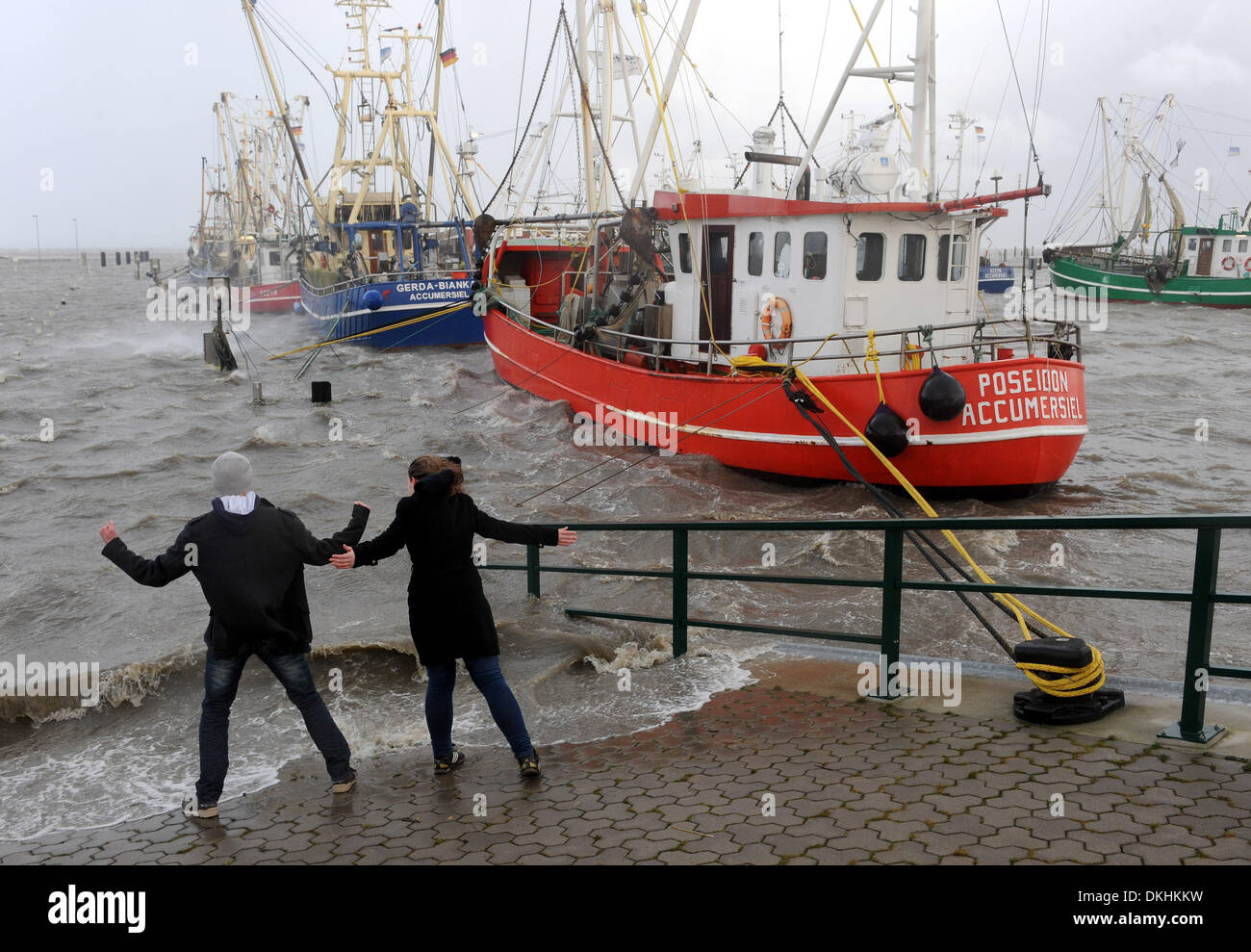 Dornumer Siel, Germany. 06th Dec, 2013. A young couple plays with the