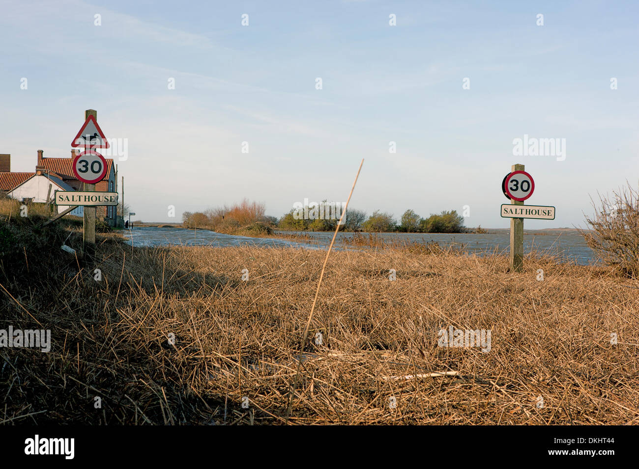 Cley, Norfolk, UK. 06th Dec, 2013. Flood waters from the biggest storm surge in 60 years inundate a coastal road in Cley in Norfolk UK, leaving reeds and branches strewn across the road. December 6 2013, 1pm Credit:  Tim James/The Gray Gallery/Alamy Live News Stock Photo