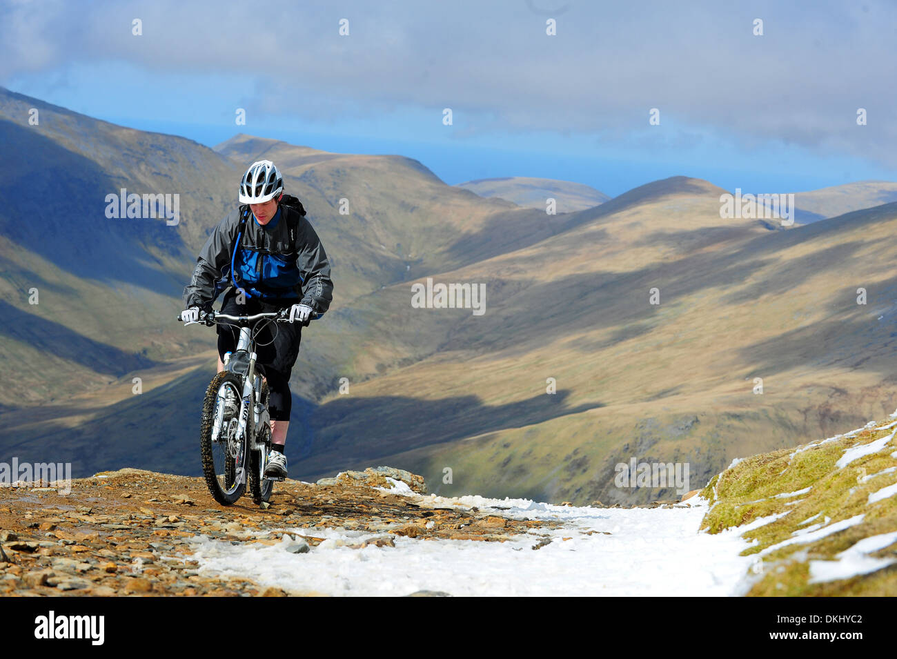 A mountain biker rides up the Llanberis Path to the summit of Mount Snowdon in Snowdonia National Park. Stock Photo