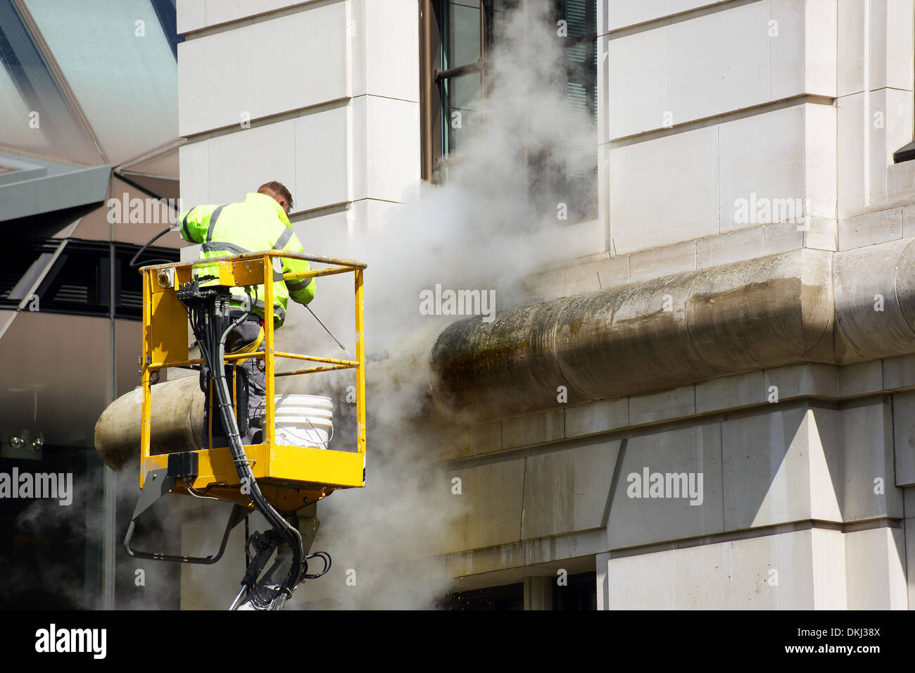 a worker washes the facade of the building Stock Photo